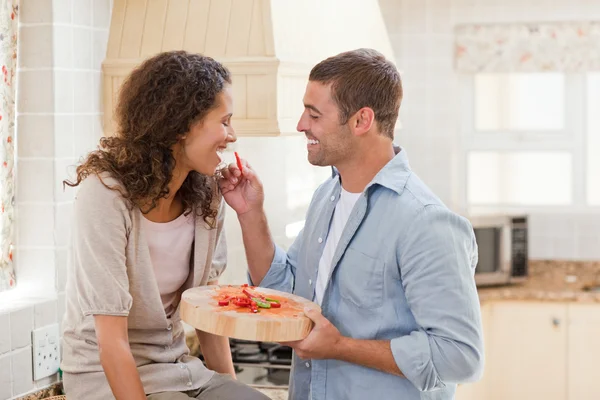 Gli amanti mangiano una fragola nella loro cucina — Foto Stock
