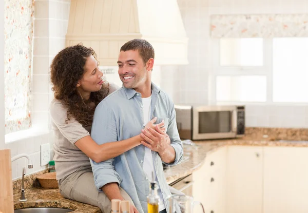 Beautiful couple hugging in the kitchen — Stock Photo, Image