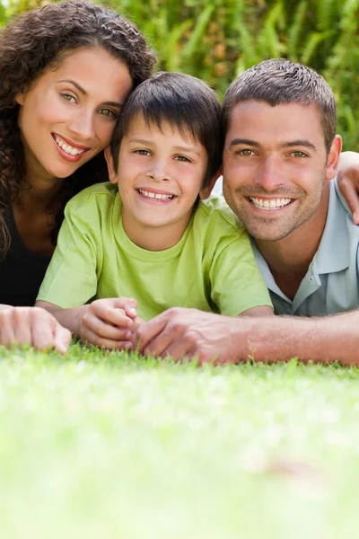 Little boy with his parents lying down in the garden — Stock Photo, Image