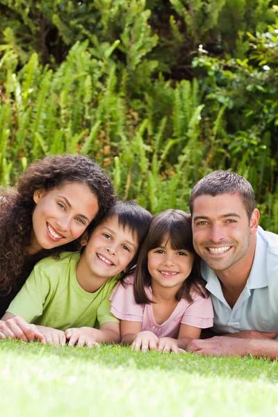Gelukkige familie liggen in de tuin — Stockfoto