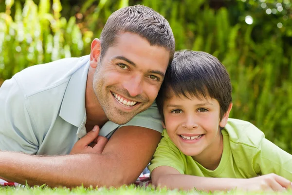 Vader met zijn zoon liggen in de tuin — Stockfoto