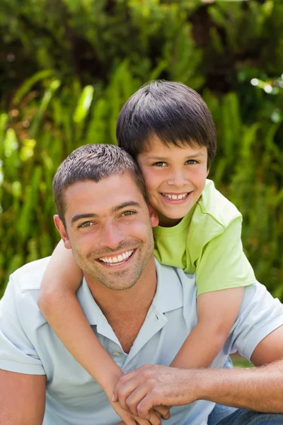 Vader met zijn zoon knuffelen in de tuin — Stockfoto