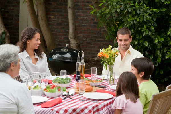 Щаслива сім'я їсть у саду — стокове фото