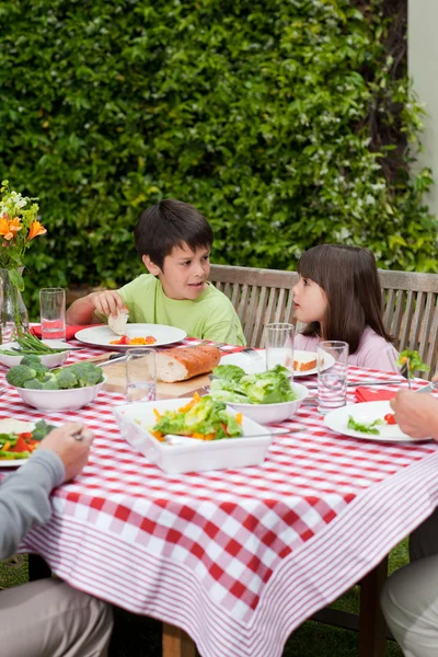 Gelukkige familie eten in de tuin — Stockfoto