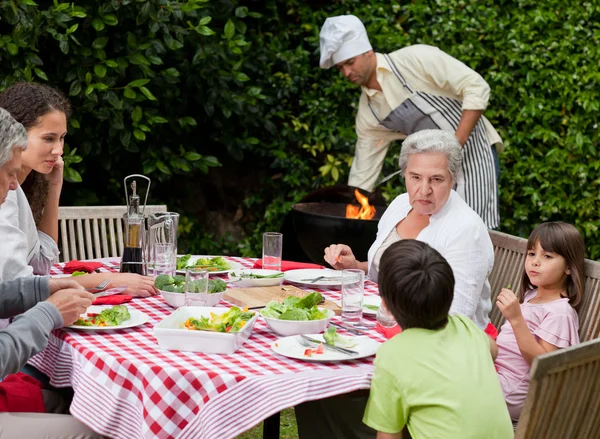 Glückliche Familie beim Essen im Garten — Stockfoto