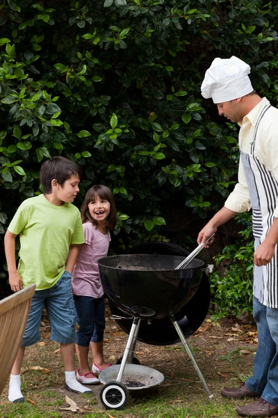 Familie met een barbecue in de tuin — Stockfoto