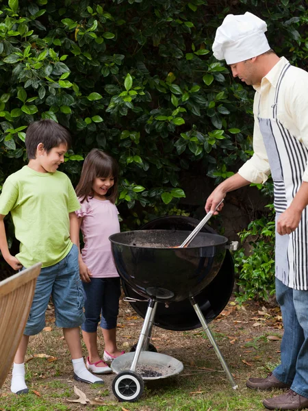 Familie met een barbecue in de tuin — Stockfoto