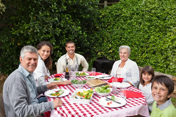 Šťastná rodina jíst v zahradě — Stock fotografie