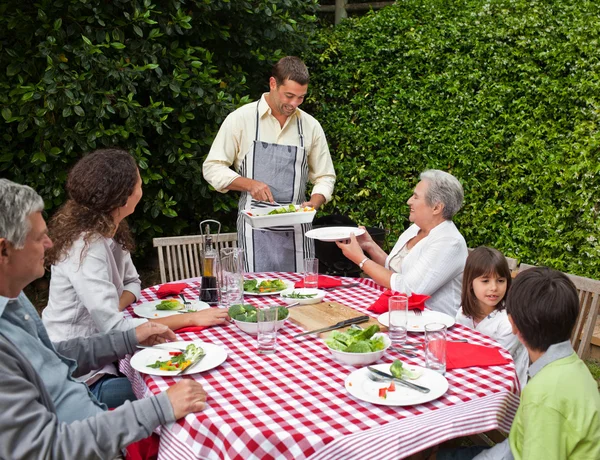 Man serverar sin familj vid bordet — Stockfoto