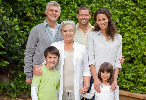 Portrait of a happy family looking at the camera in the garden — Stock Photo, Image
