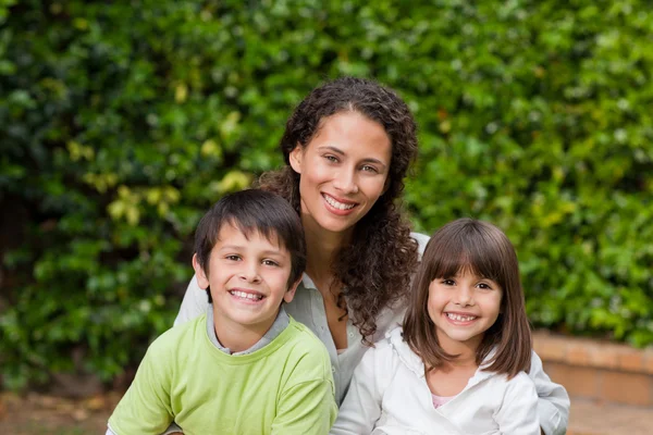 Mother with their children looking at the camera in the garden — Stock Photo, Image