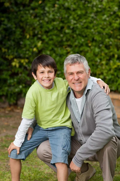Abuelo con su nieto mirando a la cámara en la garde —  Fotos de Stock
