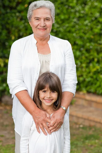 Grandmother with her granddaughter looking at the camera in the — Stock Photo, Image