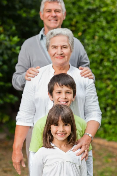 Бабусі і дідусі зі своїми дітьми дивляться на камеру в гонці — стокове фото