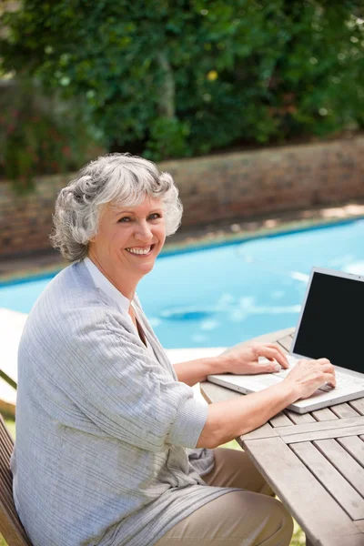 Volwassen vrouw die op haar laptop werkt — Stockfoto