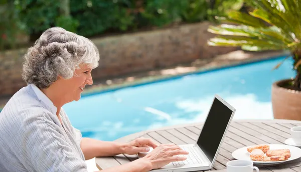 Starsza kobieta na jej laptopie — Zdjęcie stockowe