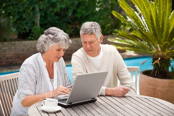 Casal aposentado trabalhando em seu laptop — Fotografia de Stock