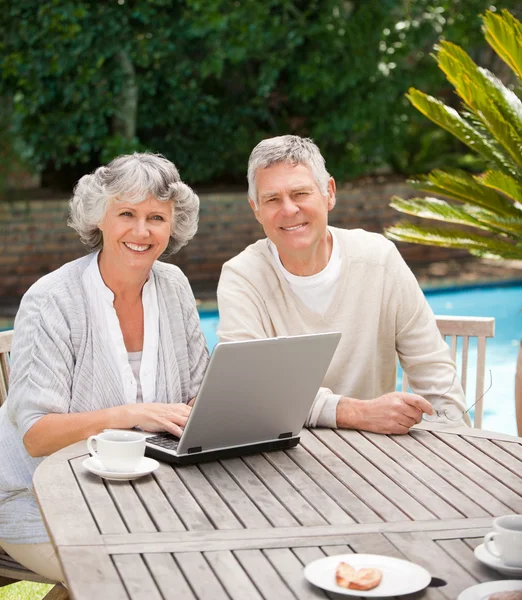 Nyugdíjas házaspár dolgozik a laptop — Stock Fotó