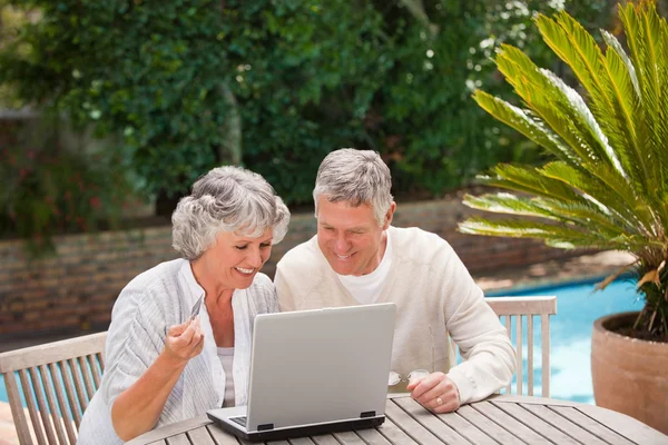 Pensionerat par köpa något på internet — Stockfoto