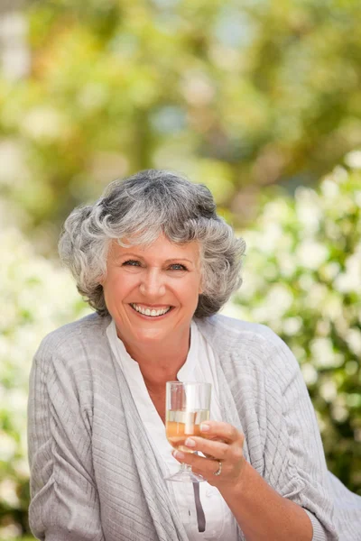 Smilimg woman with her drink of wine — Stock Photo, Image