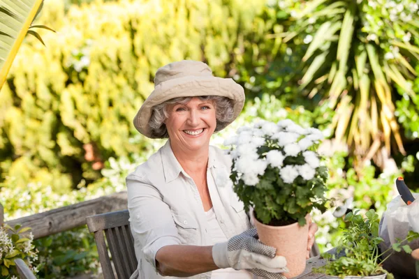 Seniorin mit Blumen im Garten — Stockfoto