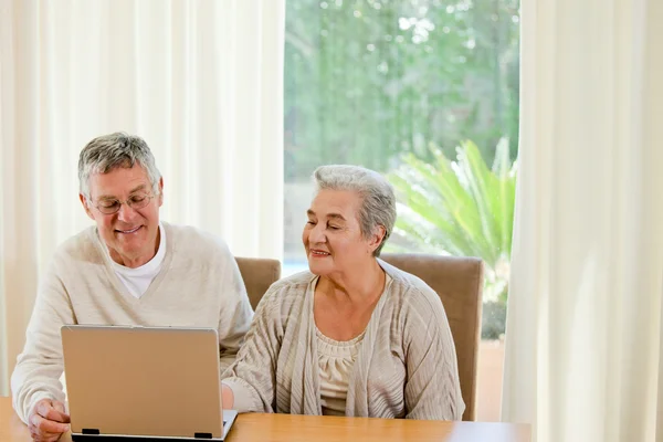 Senior couple looking at their laptop — Stock Photo, Image