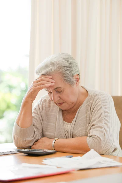 Pensionerad kvinna beräknar sina hushållsräkningar — Stockfoto