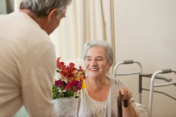 Emekli adam karısına çiçek sunan — Stok fotoğraf