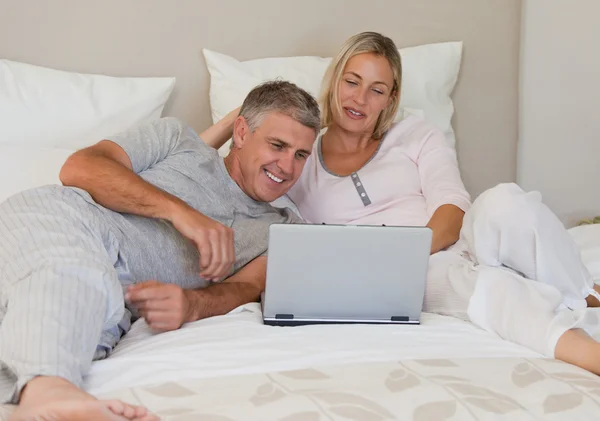 Прекрасна пара дивиться на свій ноутбук — стокове фото
