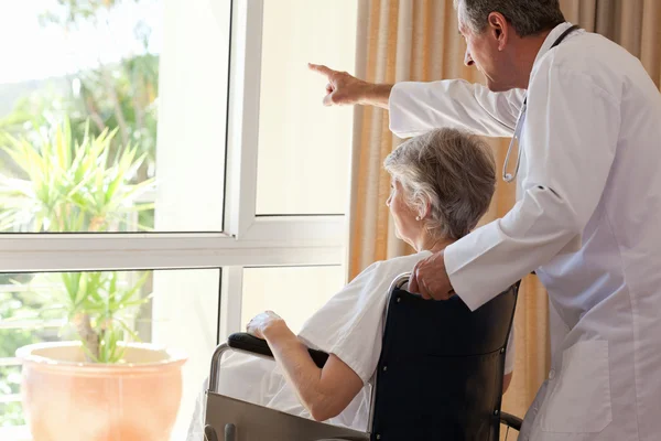 Doctor with his patient looking out the window — Stock Photo, Image