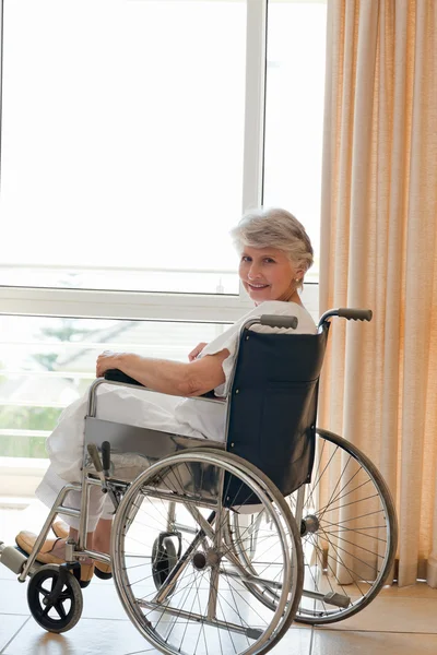 Frau im Rollstuhl blickt in die Kamera — Stockfoto