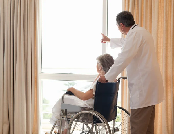 Doctor with his patient looking out the window — Stock Photo, Image