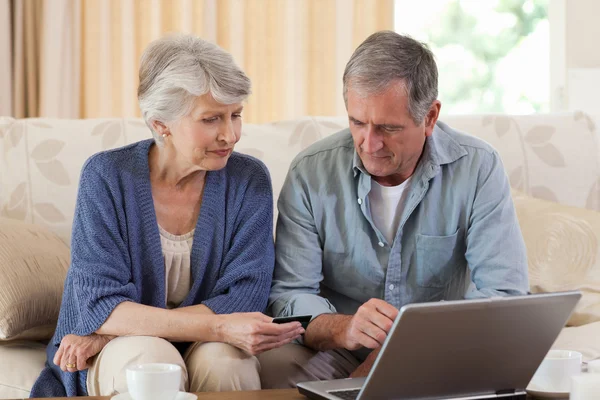 Пара пенсионеров смотрит на свой ноутбук — стоковое фото