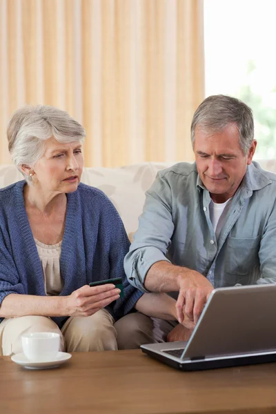 Pensionerat par titta på deras laptop — Stockfoto