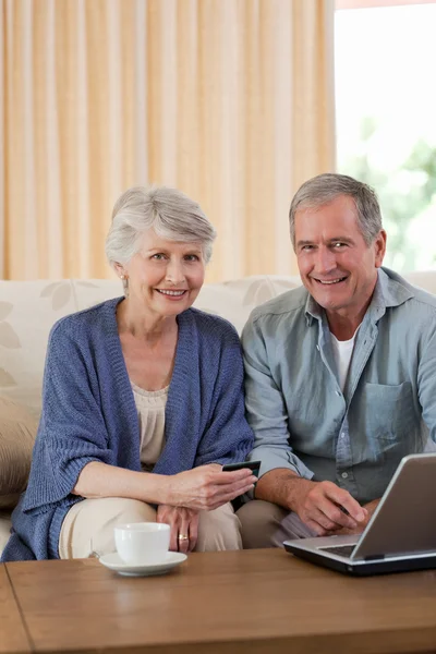 Casal aposentado olhando para seu laptop — Fotografia de Stock