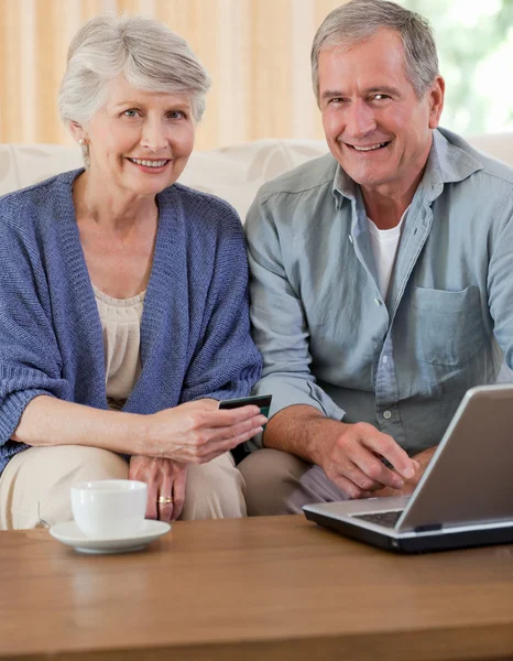 看着他们的笔记本电脑对退休的夫妇 — 图库照片