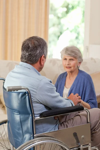 Seniorenpaar aan het praten in de woonkamer thuis — Stockfoto