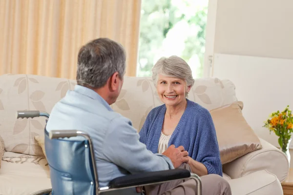 Пожилая пара разговаривает в гостиной на дому — стоковое фото