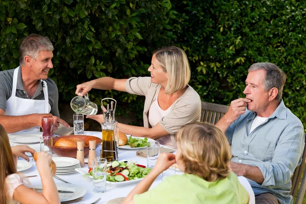Prachtige familie eten in de tuin — Stockfoto