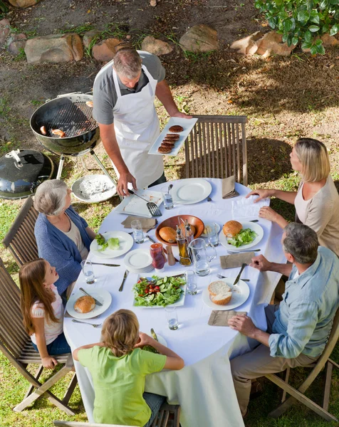 Szép család eszik a kertben — Stock Fotó
