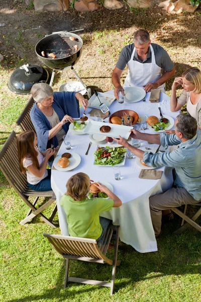 Очаровательная семья ест в саду — стоковое фото