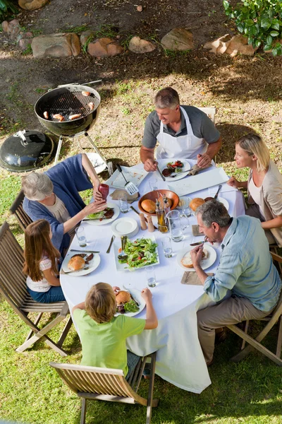 Adorable familia comiendo en el jardín — Foto de Stock