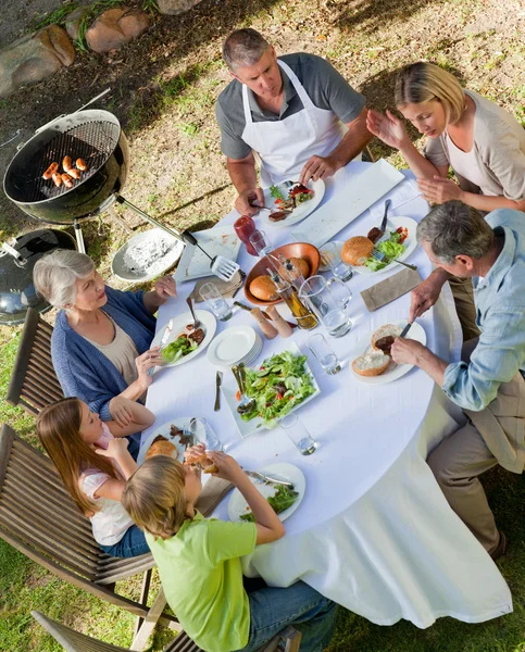Imádnivaló család eszik a kertben — Stock Fotó