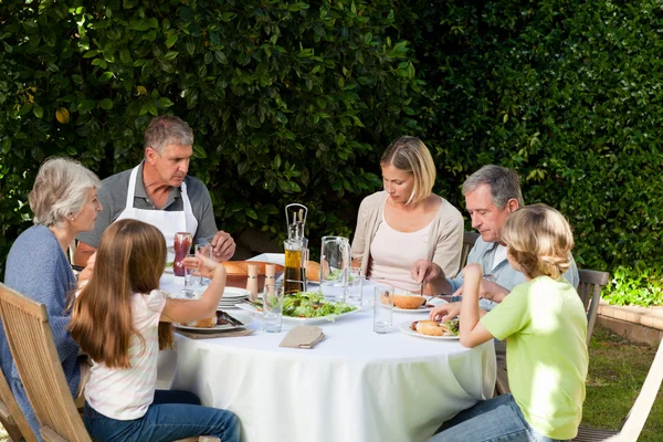 Okouzlující rodina jíst v zahradě — Stock fotografie
