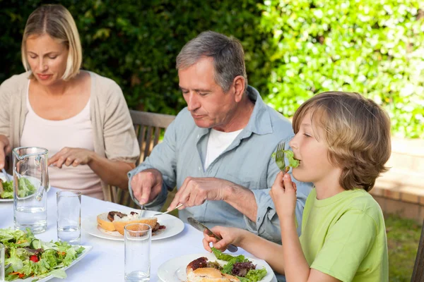 Bedårande familj äta i trädgården — Stockfoto