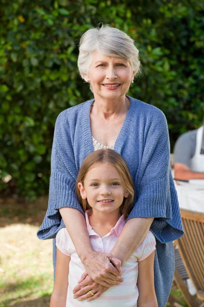 Großmutter mit ihrer Enkelin, die in die Kamera blickt — Stockfoto