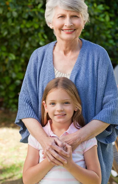 Großmutter mit ihrer Enkelin, die in die Kamera blickt — Stockfoto
