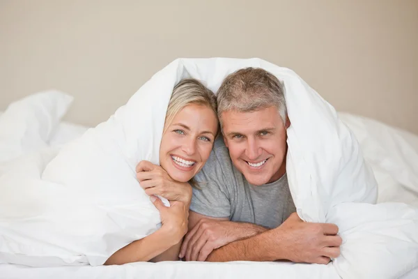 Paar legt sich zu Hause ins Bett — Stockfoto
