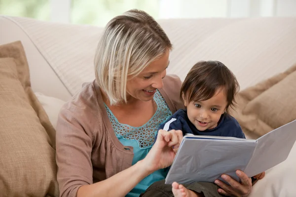 Mother looking at a book with her son — Stock Photo, Image