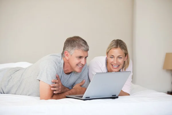 Casal encantador olhando para seu laptop — Fotografia de Stock